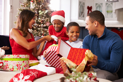 young couple and children opening their presents on Christmas morning