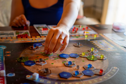 young woman placing pieces on the Terraforming Mars board