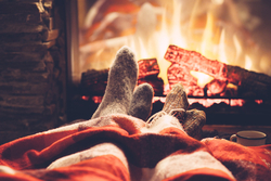 Couple relax next to each other with a log burner by their feet