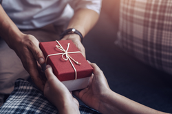 a small wrapped gift being given, close-up of hands