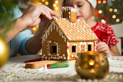 Father and daughter build a gingerbread house