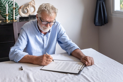 Older man signing paperwork