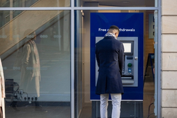  A man withdrawing money from an ATM. 