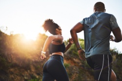 A couple running through a park.
