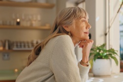 A woman looking out of the window at home. 