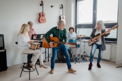 A group of people in their 50s playing musical instruments in a band.