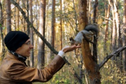 A man feeding a squirrel.