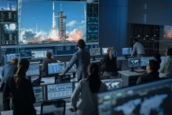 People in mission control watching a rocket launch.