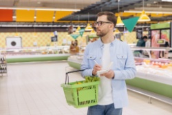 A man in a shop holding a basket.